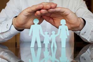 Hands over paper cutout of family